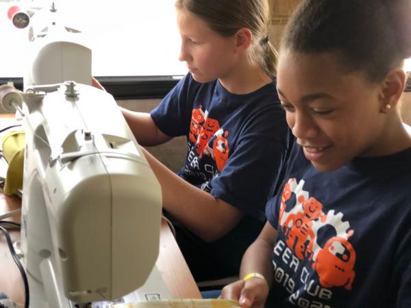 Girls at their sewing machines on the Creativity Shell bus
