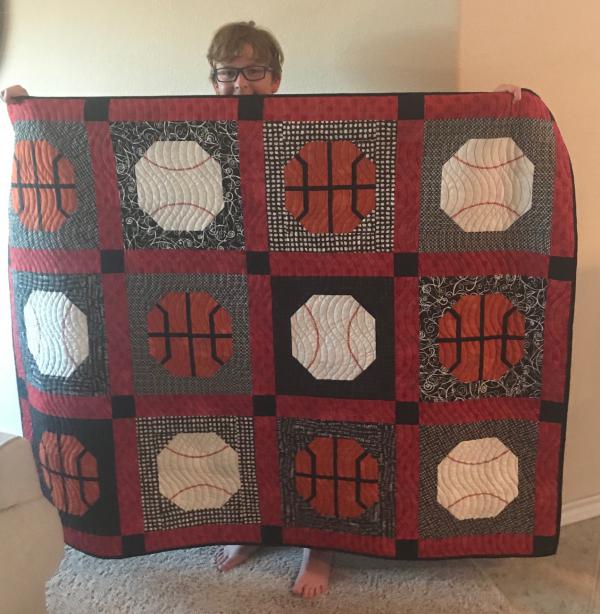 Debbie Outlaw's son Jackson with quilt